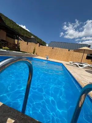 a large blue swimming pool in front of a house at Uysal Dağevleri in Bilecik