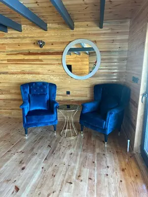 two blue chairs in a room with wooden walls at Uysal Dağevleri in Bilecik