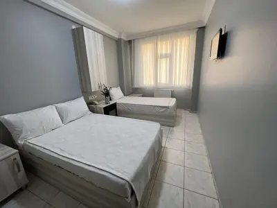 a small bedroom with two beds and a window at Hotel Prima in Istanbul