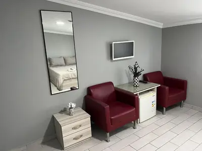 a room with a chair and a mirror and a bed at Hotel Prima in Istanbul