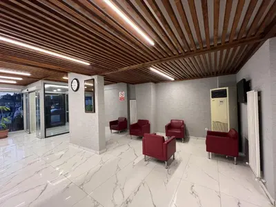 a waiting room with red chairs and a clock at Hotel Prima in Istanbul
