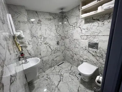 a marble bathroom with a toilet and a sink at Hotel Prima in Istanbul