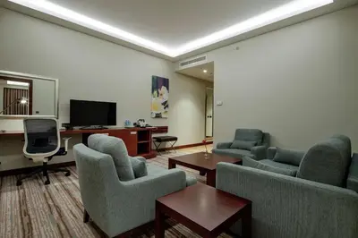 a living room with chairs and a desk and a tv at Hilton Garden Inn Corlu in Corlu
