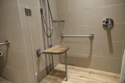 a shower with a wooden stool in a bathroom at Hilton Garden Inn Corlu in Corlu