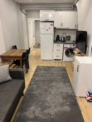 a kitchen with a white refrigerator and a table at AYD Apart Elmadağ Taksim in Istanbul