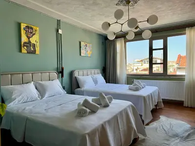 a bedroom with two beds with white sheets and a chandelier at Mansion Istanbulite in Istanbul