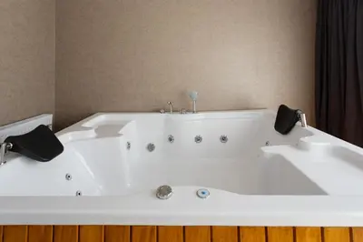 a white bath tub with two faucets at Atm Suit Otel in Istanbul
