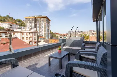 a balcony with chairs and a couch on a roof at Atm Suit Otel in Istanbul