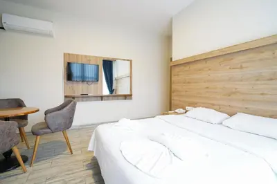 a bedroom with a bed and a table and a mirror at Askoroz Otel İzmit in Izmit