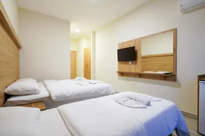 a hotel room with two beds and a mirror at Askoroz Otel İzmit in Izmit