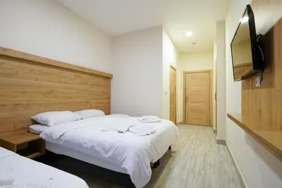 a bedroom with two beds and a flat screen tv at Askoroz Otel İzmit in Izmit