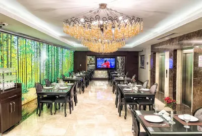 a dining room with tables and chairs and a chandelier at The Conforium Hotel İstanbul in Istanbul