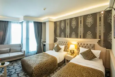 a hotel room with two beds and a couch at The Conforium Hotel İstanbul in Istanbul