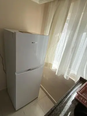 a white refrigerator in a kitchen next to a window at ilkim&derin suite in Istanbul