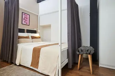 a bedroom with a bed with a mirror and a stool at Stunning Apartment at Unbeatable Location in Istanbul