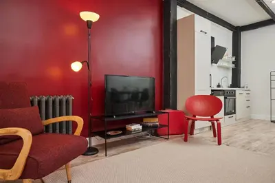 a living room with a red wall and a television at Stunning 2BR 1 Min Metro&Galata in Istanbul
