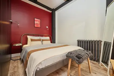 a bedroom with a bed with a red wall at Stunning 2BR 1 Min Metro&Galata in Istanbul