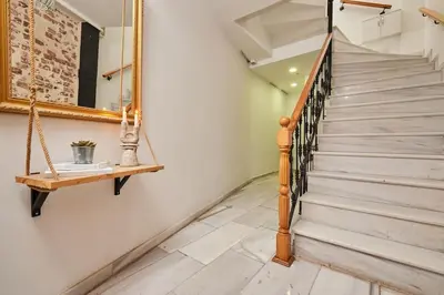 a staircase with a wooden rail and a shelf at Stunning 2BR 1 Min Metro&Galata in Istanbul