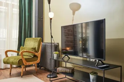 a living room with a television and a chair at Stunning 2BR 1 Min Metro&Galata in Istanbul