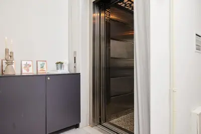 a black refrigerator in a hallway next to a wall at Stylish 2BR Apt Galata-Taksim Area Near Metro in Istanbul
