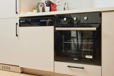 a black oven in a white kitchen at Modern 2BR Apt Galata-Taksim Area Near Metro in Istanbul