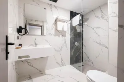a white bathroom with a sink and a shower at The Port Güzelyalı in Pendik