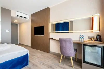 a hotel room with a bed and a desk with a chair at The Port Güzelyalı in Pendik