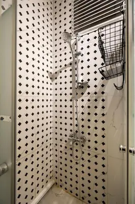 a shower in a bathroom with black and white tiles at sevim suites Nişantaşı Center in Istanbul