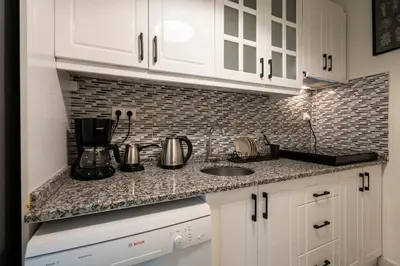 a kitchen with white cabinets and a counter top at sevim suites Nişantaşı Center in Istanbul
