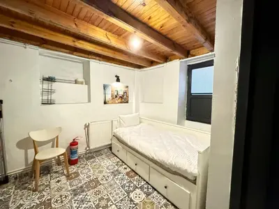 a bedroom with a bed and a chair and a window at The Wooden 17 in Istanbul