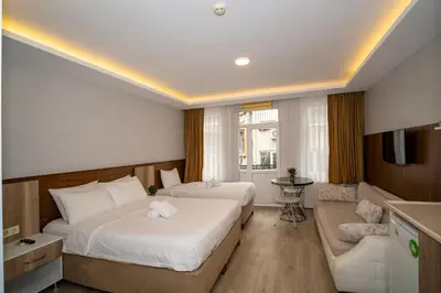 a hotel room with two beds and a couch at New Life Taksim Apart Hotel in Istanbul