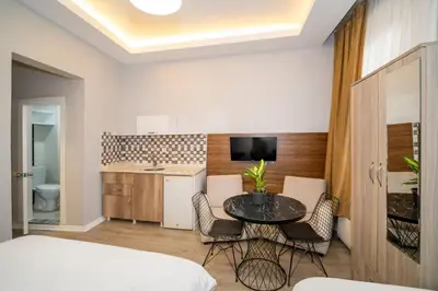 a room with a table and chairs and a kitchen at New Life Taksim Apart Hotel in Istanbul