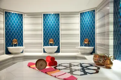 a room with three sinks and a table with flowers on the floor at Dosso Dossi Hotels & SPA Downtown in Istanbul