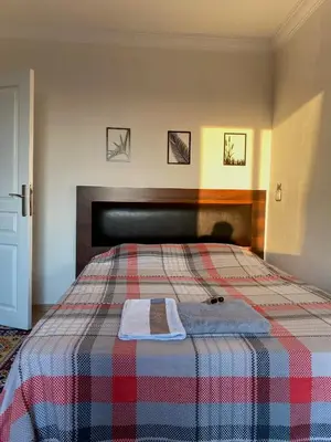 a bedroom with a bed with a plaid blanket at Daily airport aparthotel in Taşoluk