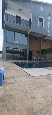 a large building with a swimming pool in front of it at Naturel villaları in Orhangazi