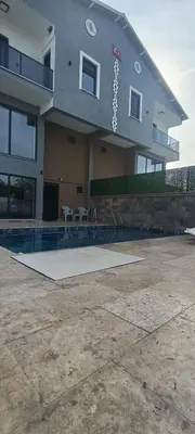 a large building with a swimming pool in front of it at Naturel villaları in Orhangazi