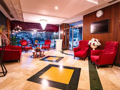 a waiting room with red chairs and a tv at Royal Capital Hotel Bursa in Bursa