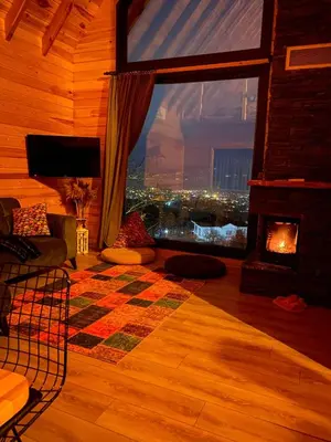 a living room with a fireplace and a view of a city at papatya in Sapanca