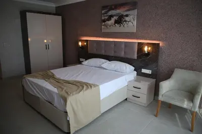 a bedroom with a large bed and a chair at Asım ve nurhan kocabıyık öğretmenevi in Avcılar