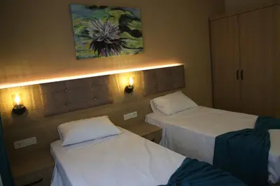 two beds in a hotel room with lights on them at Asım ve nurhan kocabıyık öğretmenevi in Avcılar