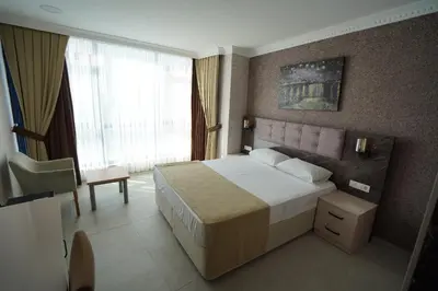 a bedroom with a large bed and a large window at Asım ve nurhan kocabıyık öğretmenevi in Avcılar