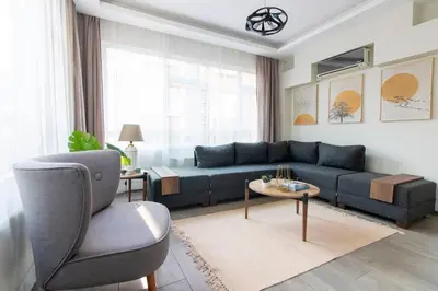 a living room with a blue couch and a chair at Pretty Corner Flat with Abundant Light in Kadikoy in Istanbul