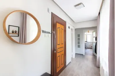 a hallway with a wooden door and a mirror at Pretty Corner Flat with Abundant Light in Kadikoy in Istanbul