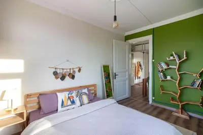 a bedroom with a bed and a green wall at Soft and Historic 3BR Home w Iconic Haydarpasa View in Istanbul