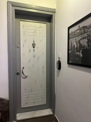 a white door in a room with a picture at ŞAHİN PERA SUİT 1 stylish 2Br 3Ac apartment near Istiklal street in Istanbul