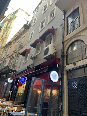 a restaurant on a street next to a building at ŞAHİN PERA SUİT 1 stylish 2Br 3Ac apartment near Istiklal street in Istanbul
