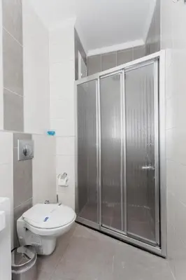 a white bathroom with a shower and a toilet at Zengin City Hotel in Istanbul