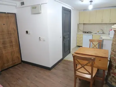 a kitchen with a wooden table and a wooden door at Istanberry - Pera Apartments in Istanbul