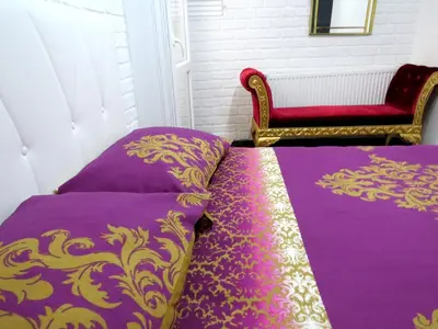 a bed with purple and gold sheets and a chair at Istanberry - Pera Apartments in Istanbul
