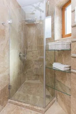 a shower with a glass door in a bathroom at Architect Jonas generous 85 sqm apartment full of Art in Istanbul